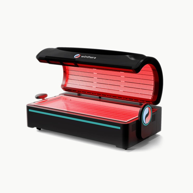 Geöffnete Winthera Red Bed Lichttherapie-Liege in Schwarz mit aktivem Rotlicht